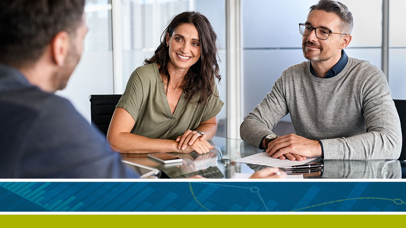 Couple souriant assis à un bureau travaillant avec leur conseiller en sécurité financière